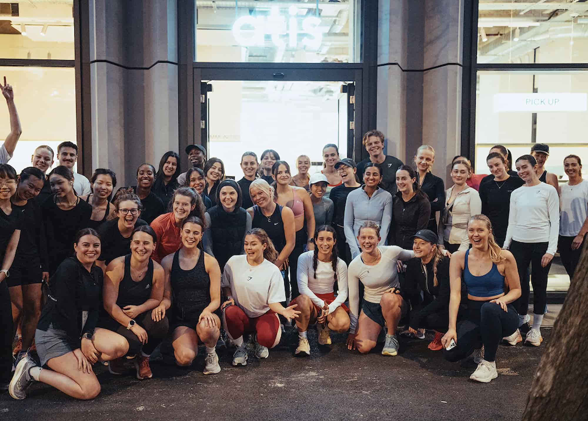 Large group of runners in activewear gathered outside an atis London restaurant for an atis Moves run club community event